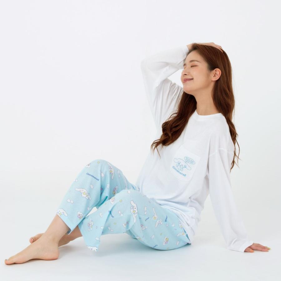 Smiling woman sitting comfortably in a Cinnamoroll pajama set with a detailed view of the embroidered pocket design.