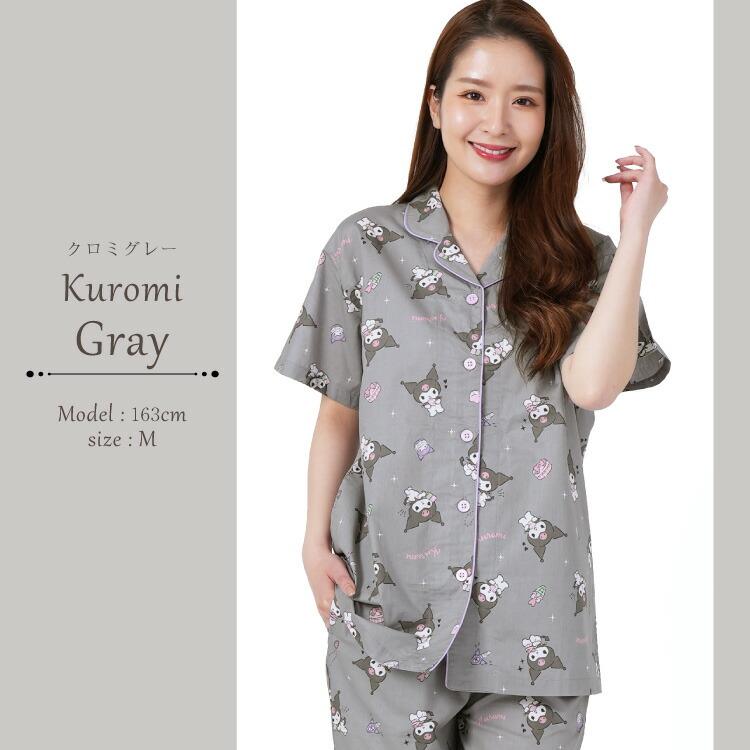 Smiling woman modeling a Kuromi gray pajama set, featuring a playful pattern of the Kuromi character on a button-up shirt and pants