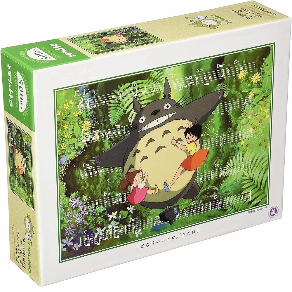 Box of Studio Ghibli Totoro Sanpo 500-piece jigsaw puzzle showing Totoro dancing with Satsuki and Mei in a lush green forest, surrounded by music notes.