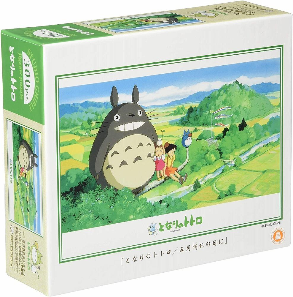 Box of My Neighbor Totoro 300-piece jigsaw puzzle showing Totoro, Mei, and Satsuki sitting on a branch overlooking a lush countryside on a sunny day.