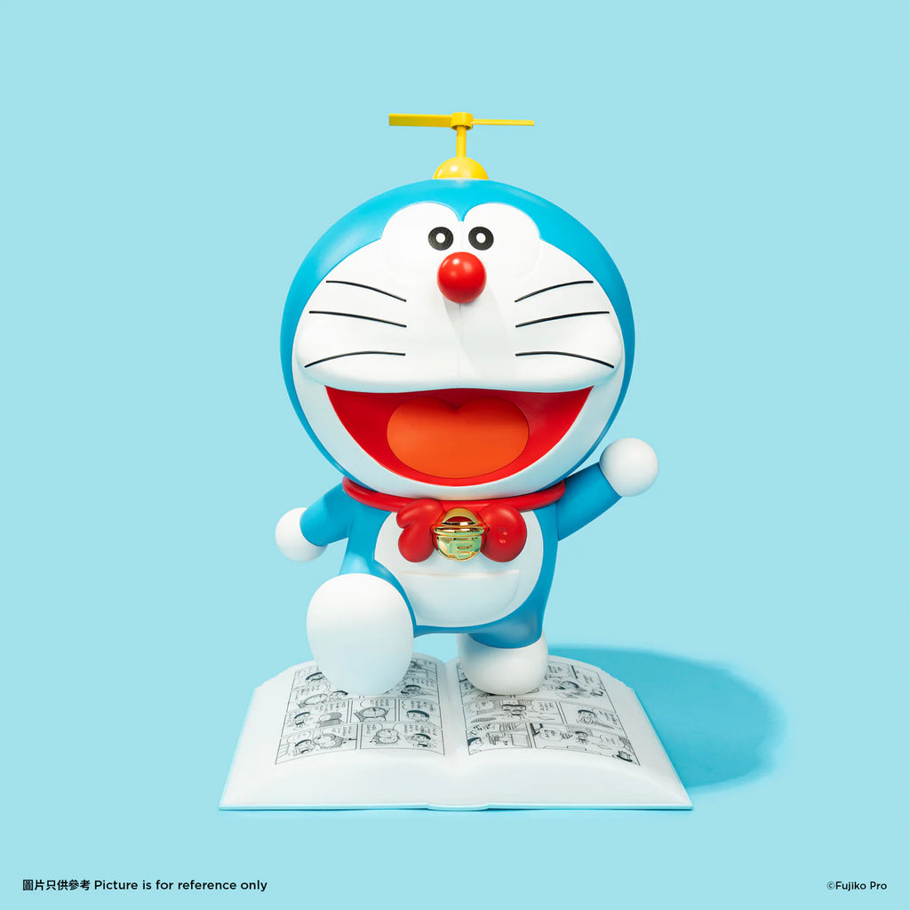 Doraemon night lamp featuring Doraemon standing on an open comic book, with a yellow propeller on his head, smiling brightly against a blue background.