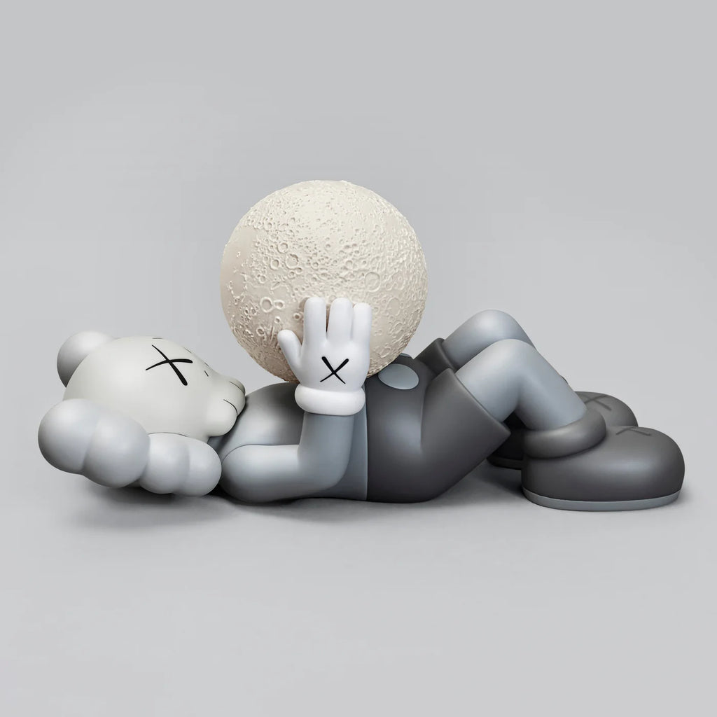 KAWS SHANGHAI Grey figure lying down, holding a detailed moon model.