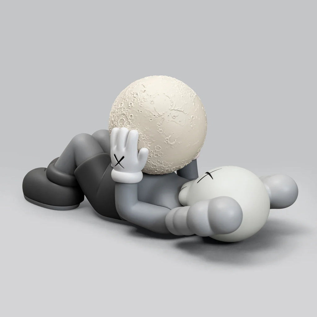 Close-up of the KAWS SHANGHAI Grey figure with a moon model resting on its body.