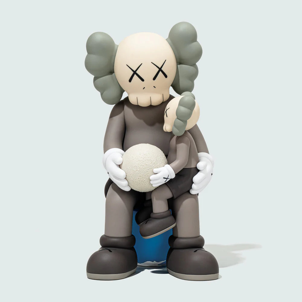 kaws:HOLIDAY THAILAND Brown figure front view, iconic Companion character holding textured glowing moon, seated on blue Earth sphere.