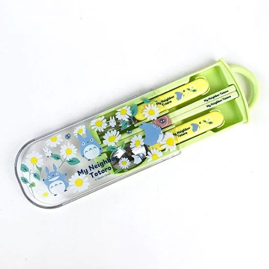 Top view of a My Neighbor Totoro-themed cutlery set in a green case, showcasing yellow handles with Totoro graphics and white daisies on the transparent lid.