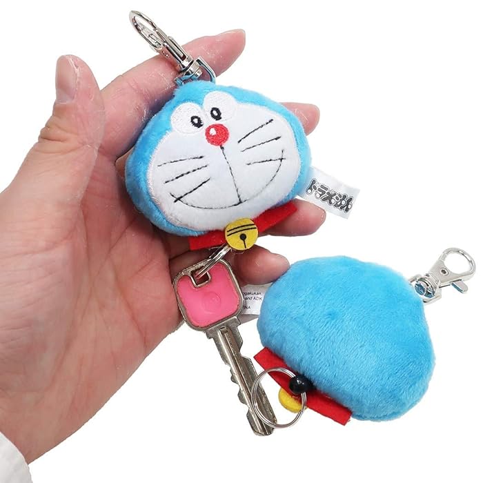 Doraemon plush keyring shown in hand with keys attached, size 7cm x 11cm.
