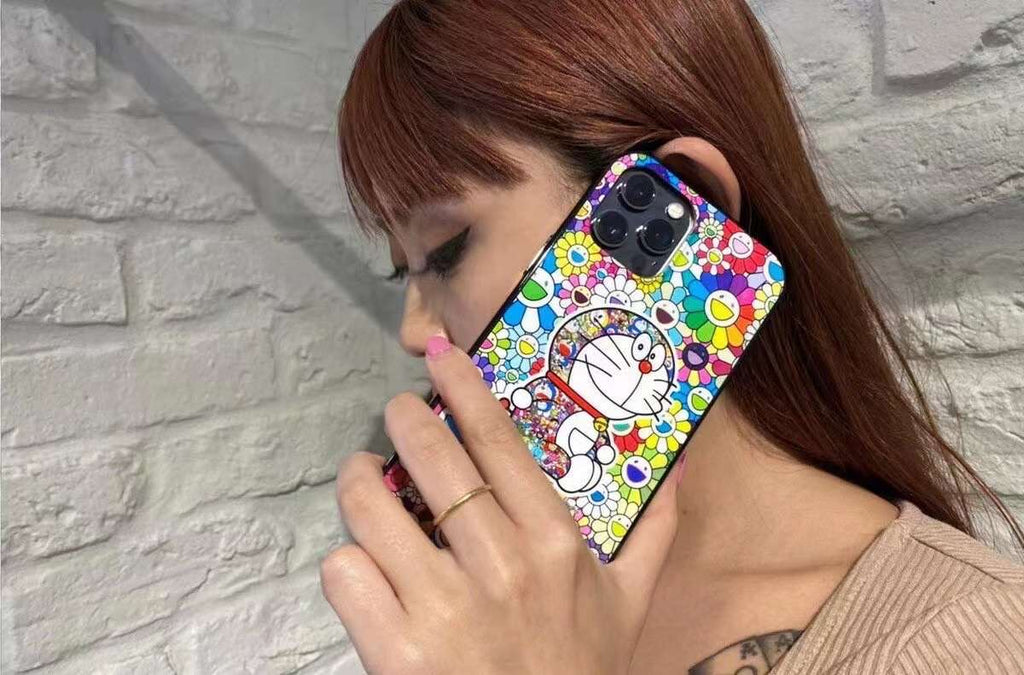 Doraemon phone case held by a model, showcasing vibrant Murakami flower pattern