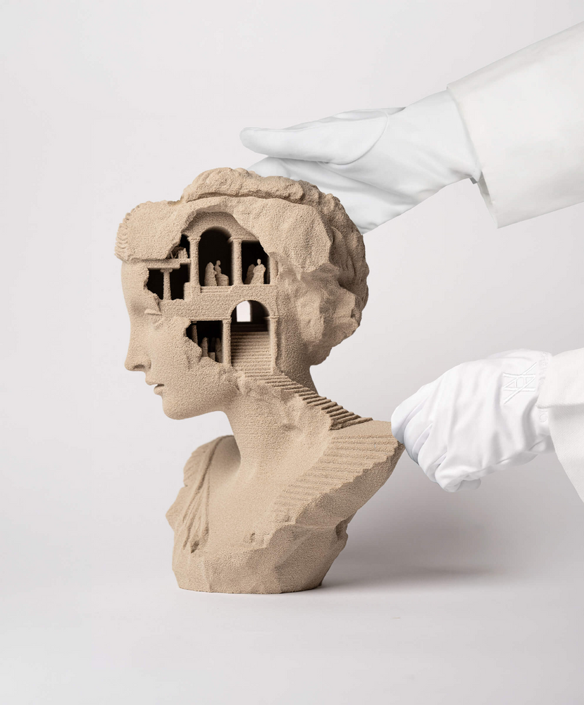 Gloved hands presenting the limited-edition sand sculpture