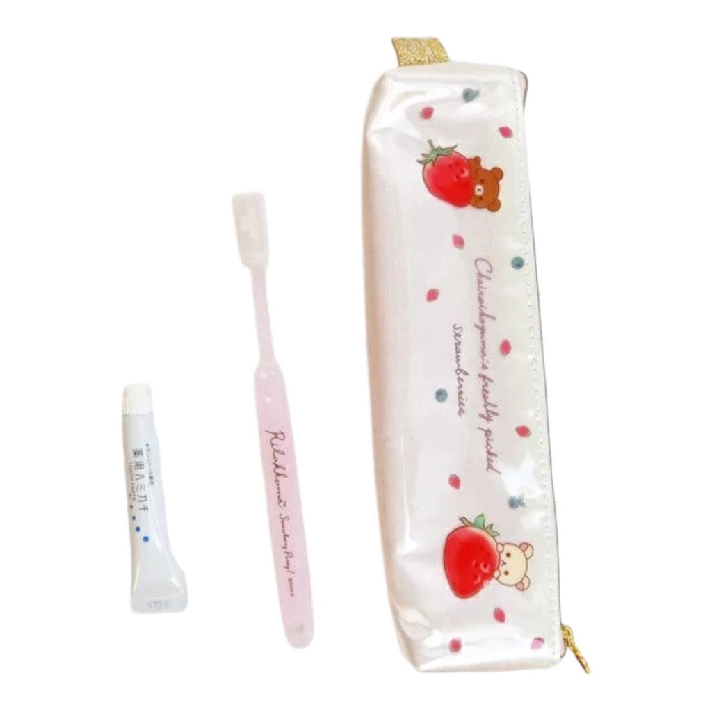 Rilakkuma Toothbrush Set featuring a pink toothbrush, travel-sized toothpaste, and a strawberry-themed pouch.