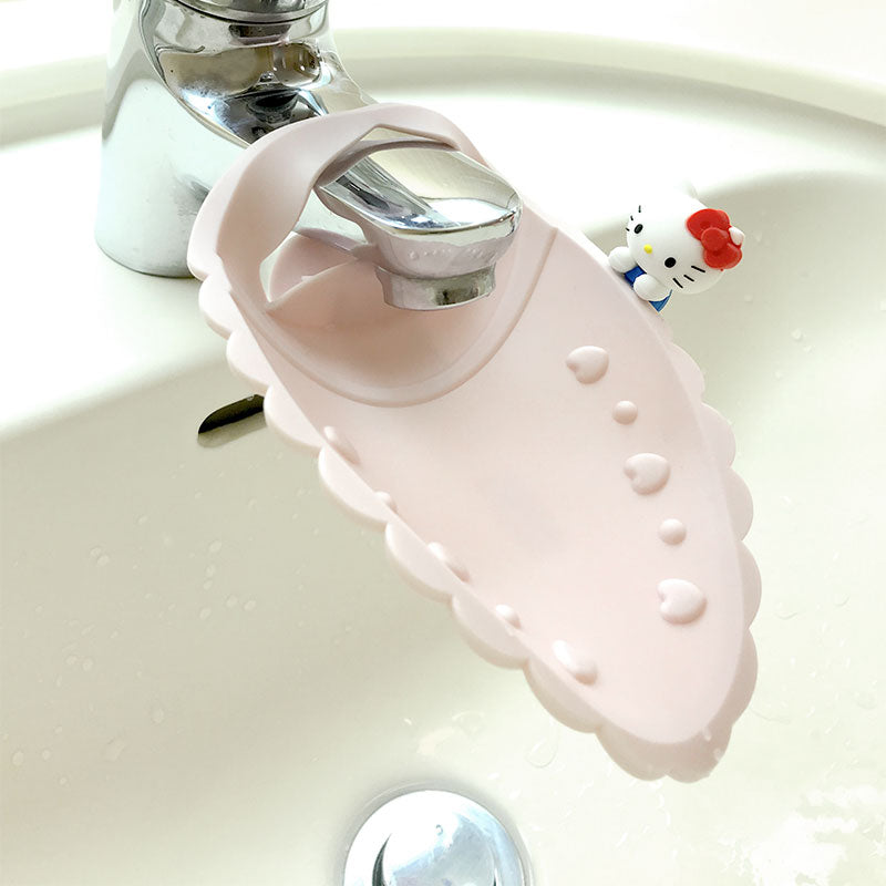 A pink Hello Kitty faucet extender placing on the faucet with Hello Kitty's signature bow.