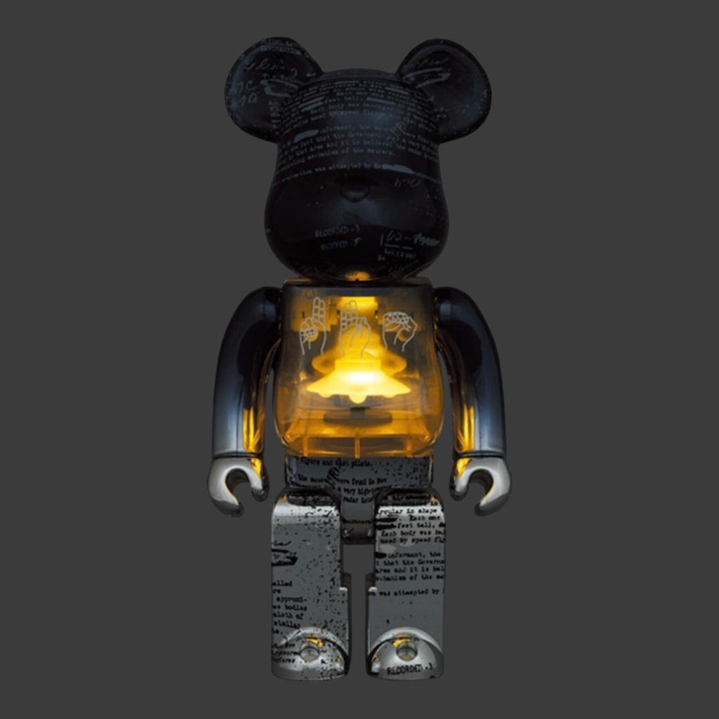 Bearbrick UFO 2nd version with illuminated inner light, showcasing the toy's detailed black script and hand graphics.