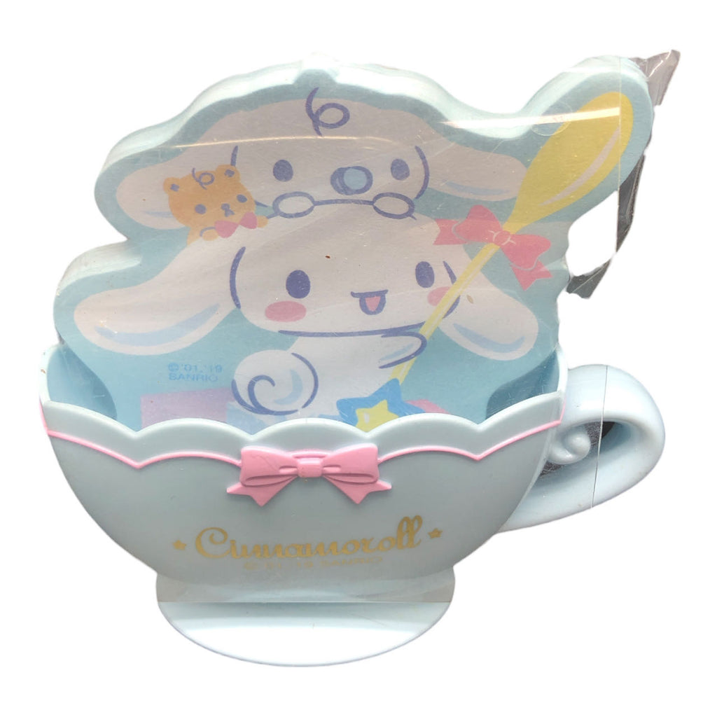 Sanrio Cinnamoroll notepad shaped like a teacup, with the character depicted holding a magic wand, set against a pastel blue and pink color palette with a whimsical design.