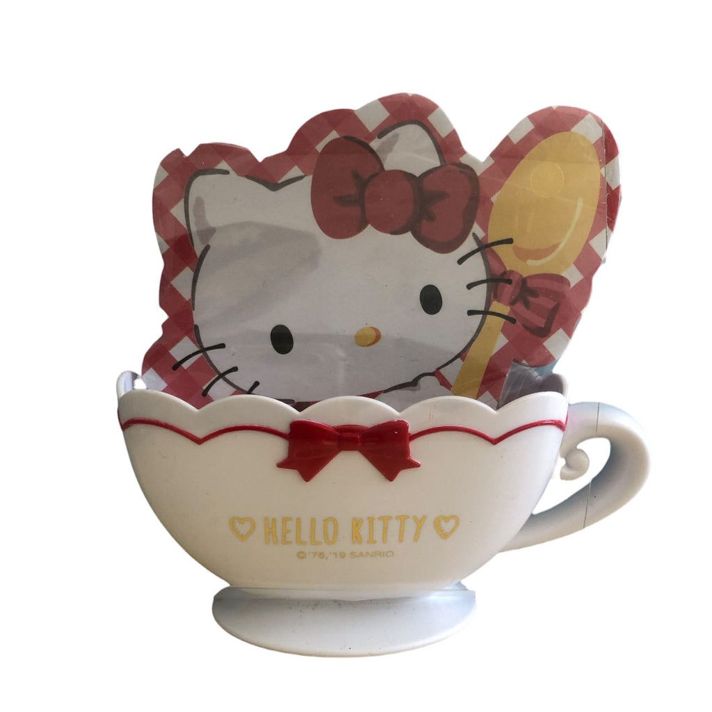 Hello Kitty themed notepad paired with a cute cup stand, adorned with Hello Kitty illustrations, perfect for desk organization and adding a touch of Sanrio charm.
