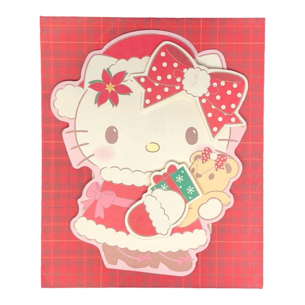 Sanrio Hello Kitty Christmas Card displayed  with Hello Kitty in a red Santa dress holding a teddy bear.