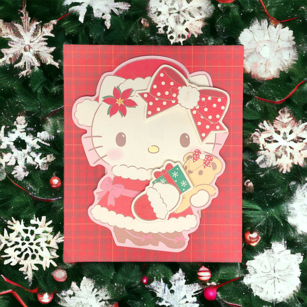 Sanrio Hello Kitty Christmas Card displayed against a festive background, with Hello Kitty in a red Santa dress holding a teddy bear.