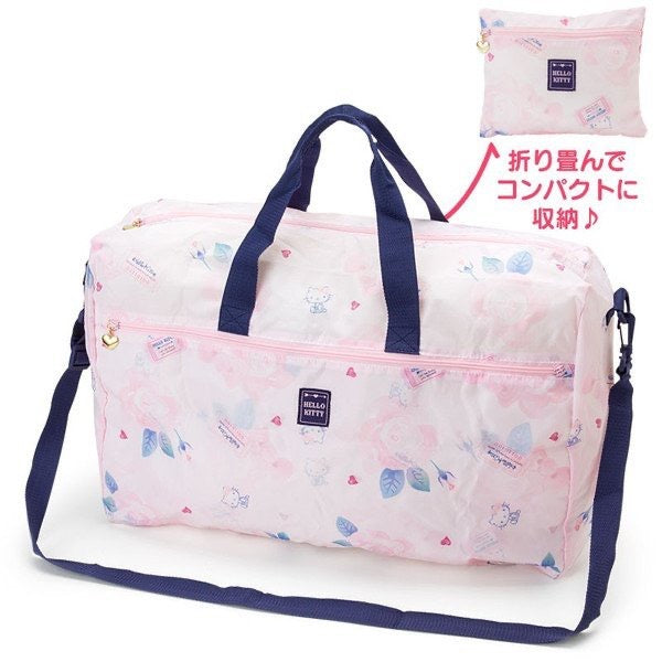 Hello Kitty-themed travel duffel bag in pink with blue straps, featuring Hello Kitty patterns and a luggage pass-through for convenience.
