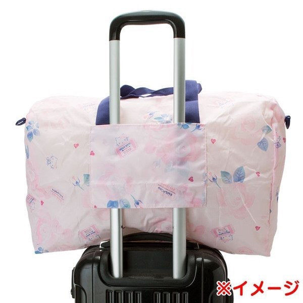 Rear view of the Hello Kitty travel duffel bag with a luggage sleeve, showcasing the compatibility with a rolling suitcase handle for easy travel.