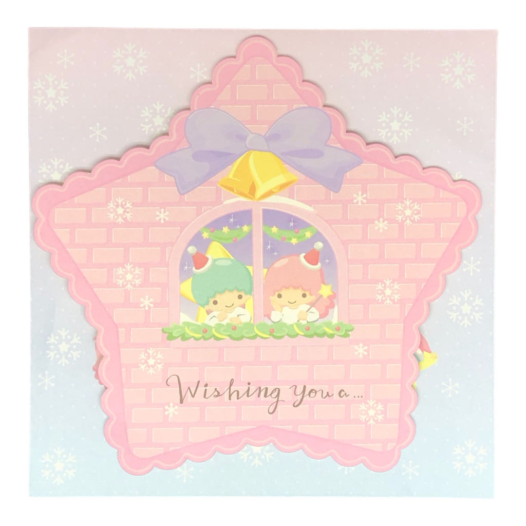 Front view of Sanrio Little Twin Stars Christmas Card with Kiki and Lala in a window adorned with a yellow bow and snowflakes