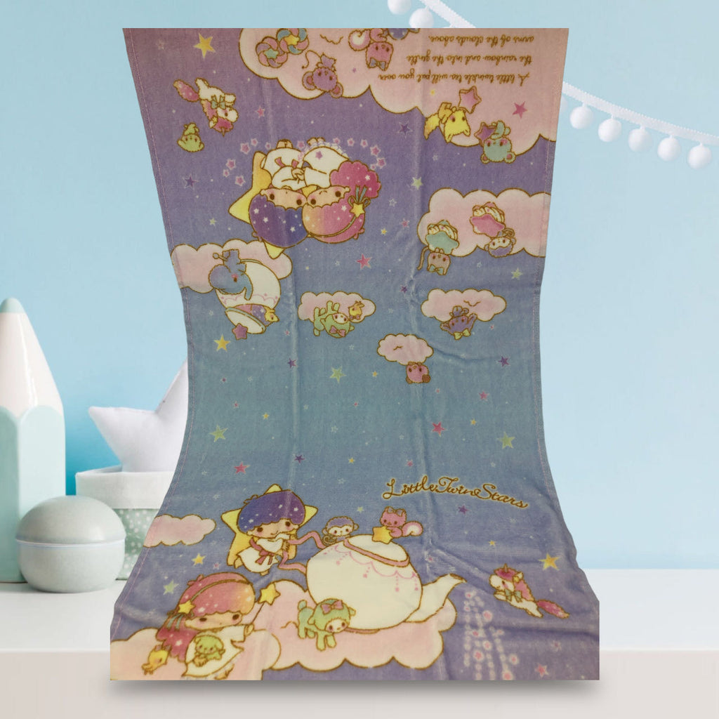 Sanrio Little Twin Stars towel with Kiki and Lala depicted among clouds and stars in a magical night sky scene, in pastel colors.
