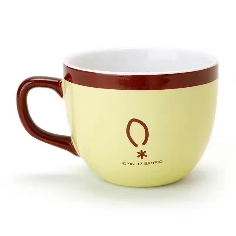 Detailed view of the Pompompurin coffee mug with a whimsical design showing Pompompurin's face on a yellow and brown mug.