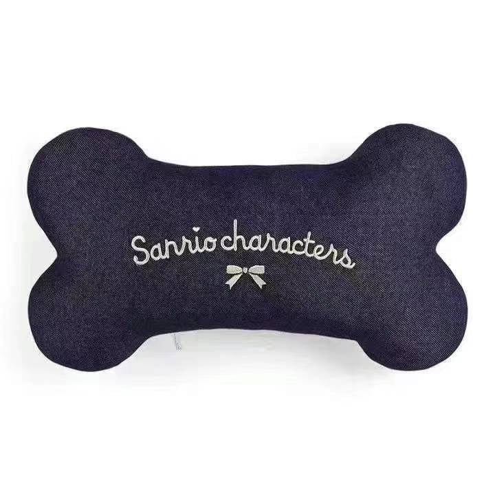 Back view of a Sanrio characters neck pillow in navy blue with the 'Sanrio characters' logo and a decorative bow detail
