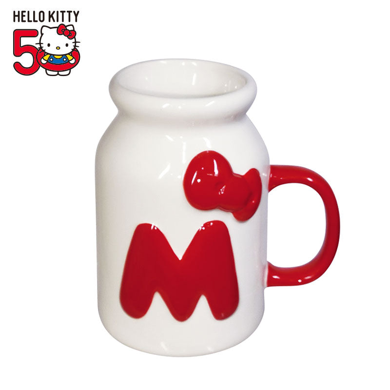 Hello Kitty 50th Anniversary milk bottle style mug with a red handle and embossed red "M" and bow on a white background.