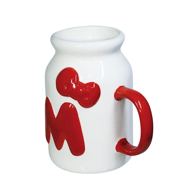 Side view of the Hello Kitty 50th Anniversary milk bottle style mug, highlighting the red handle and embossed red bow and "M" design.