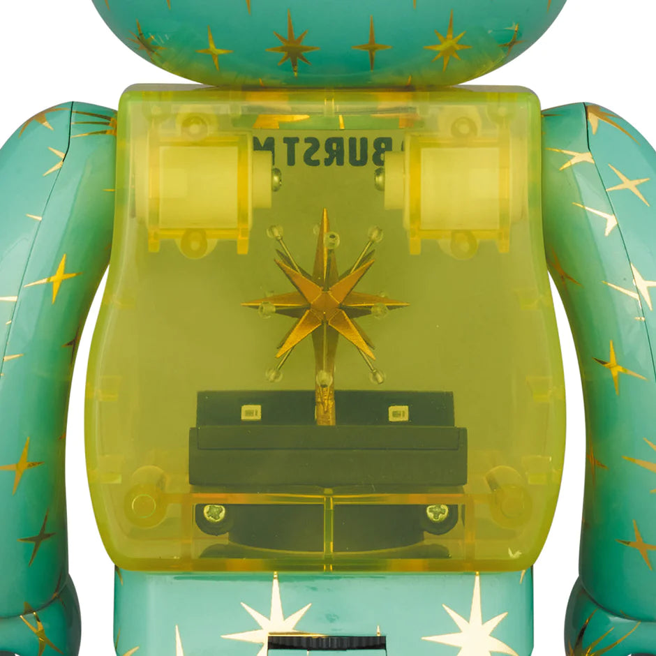 Close-up of the Bearbrick Star Burst Magic figure's torso, highlighting the intricate golden star detail and transparent chest with mechanical elements inside.