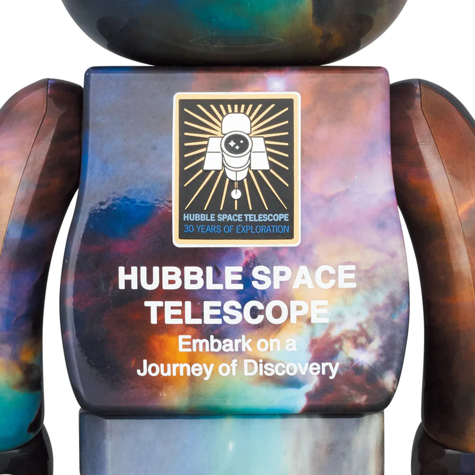 back view of Bearbrick figures in 100% and 400% sizes, adorned with the vibrant Lagoon Nebula image from the Hubble Space Telescope