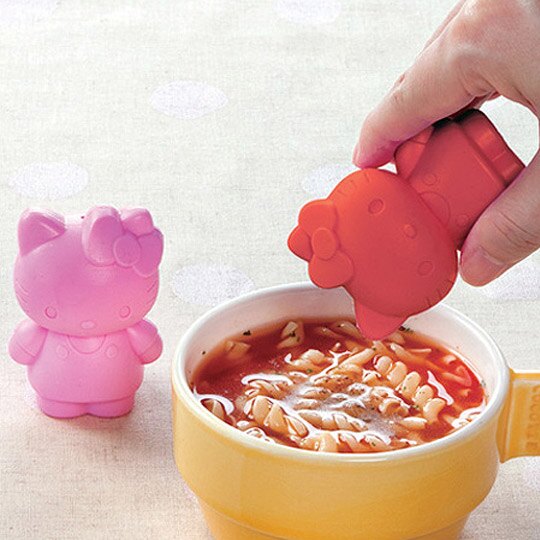 Hello Kitty Spice Shaker being used to sprinkle seasoning on soup, featuring a cute and compact design.

